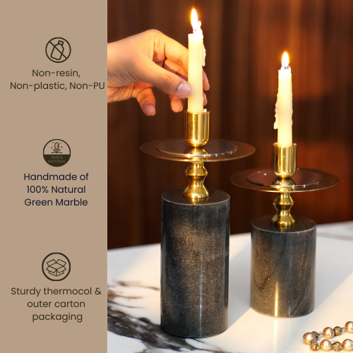 Elegant black and gold candlestick holders with lit candles on a wooden table.