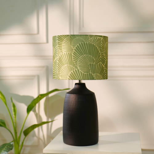 Elegant table lamp with colorful artistic shade on wooden base, placed on a desk