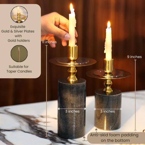 Elegant black and gold candlestick holders with lit candles on a wooden table.