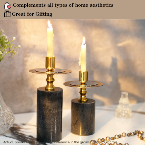 Elegant black and gold candlestick holders with lit candles on a wooden table.