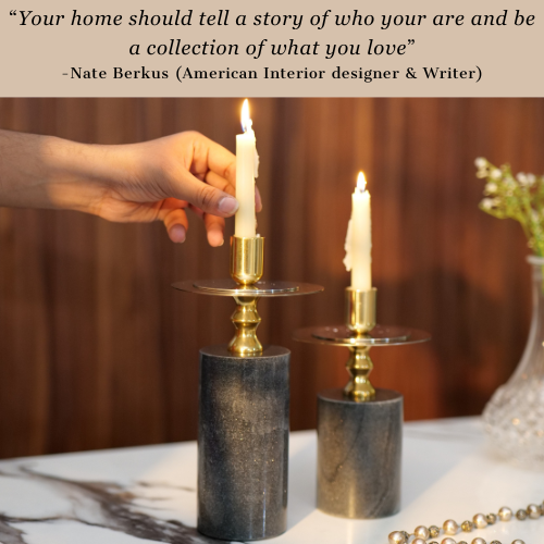 Elegant black and gold candlestick holders with lit candles on a wooden table.