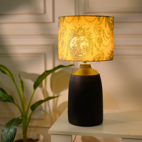 Elegant table lamp with colorful artistic shade on wooden base, placed on a desk