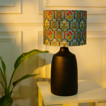 Elegant table lamp with colorful artistic shade on wooden base, placed on a desk