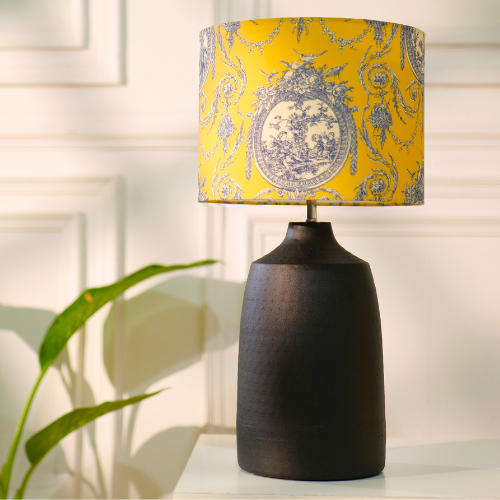 Elegant table lamp with colorful artistic shade on wooden base, placed on a desk