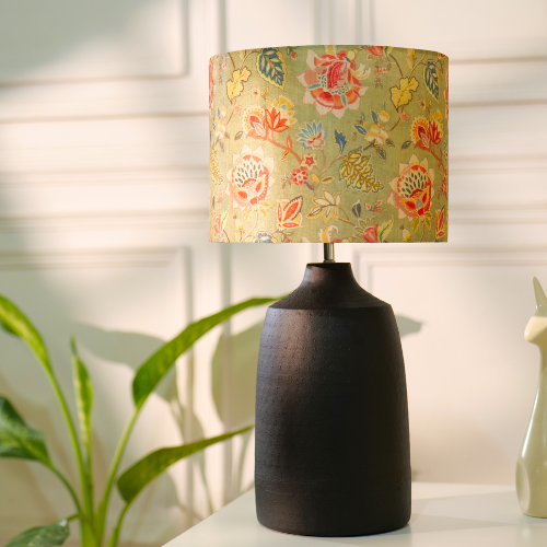 Elegant table lamp with colorful artistic shade on wooden base, placed on a desk