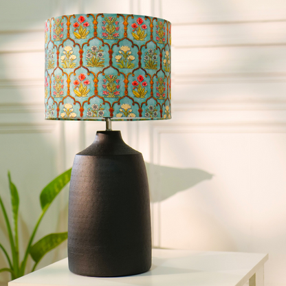 Elegant table lamp with colorful artistic shade on wooden base, placed on a desk